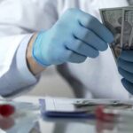 Scientists Find Moon-Like World That Doesn’t Fit Category Gloved hands in a lab coat counting US dollar bills