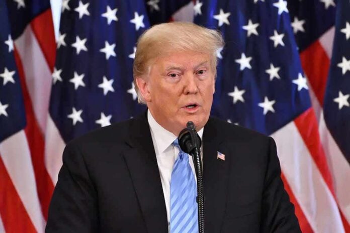 A man speaking at a podium with American flags in the background