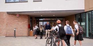 Students in uniforms arriving at a school entrance