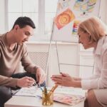 Two adults engaged in an art therapy session
