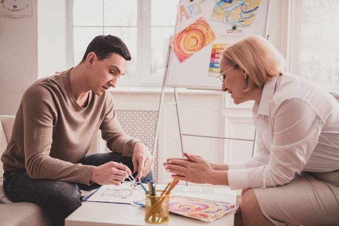Two adults engaged in an art therapy session