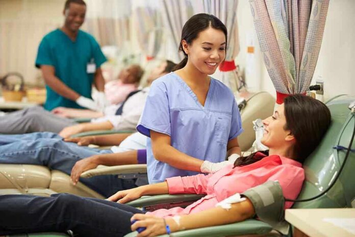shutterstock_168772919 A nurse smiling at a female donor during a blood donation session
