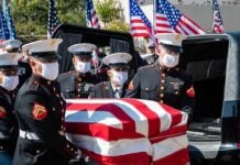 U.S. Marines carry a flag-draped casket into a hearse