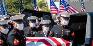 U.S. Marines carry a flag-draped casket into a hearse