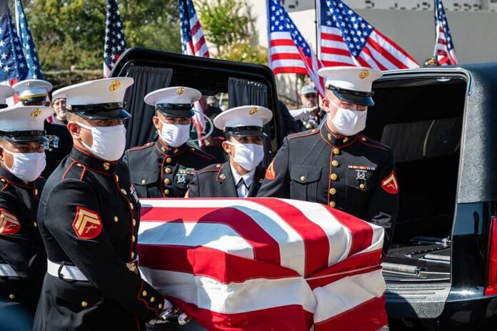 shutterstock_2042622047-1 U.S. Marines carry a flag-draped casket into a hearse
