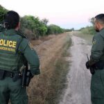 New IRA Bomb Car Nabbed Near Border Two uniformed officers stand on a rural dirt road