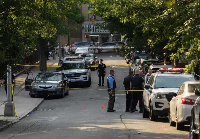 shutterstock_2330301305 Police officers secure a residential street with patrol cars and yellow tape