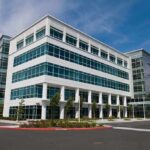 Modern office building with a glass facade and landscaped surroundings