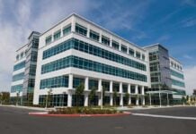 Modern office building with a glass facade and landscaped surroundings