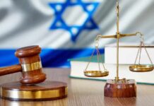 Gavel and scales of justice with Israeli flag in background