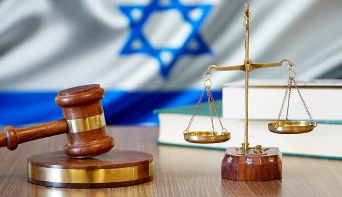 Gavel and scales of justice with Israeli flag in background