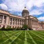 Neoclassical capitol building with dome and columns on a manicured lawn