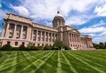 Neoclassical capitol building with dome and columns on a manicured lawn