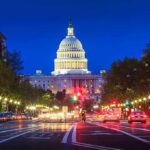 Washington’s IndyCar Funding Fight The U.S. Capitol building illuminated at night with city traffic in the foreground
