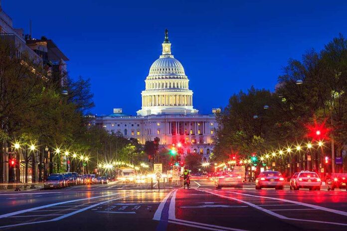 The U.S. Capitol building illuminated at night with city traffic in the foreground