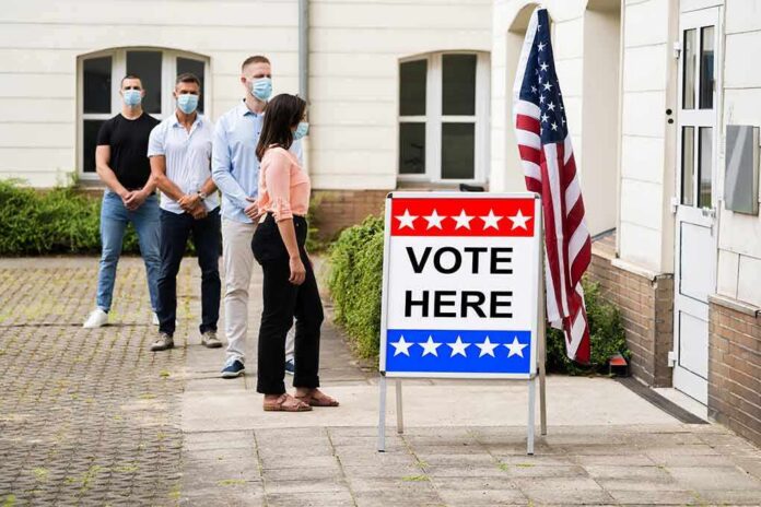 Voters wearing masks line up outside a polling place