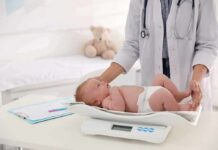 Pediatrician weighing a baby on an infant scale
