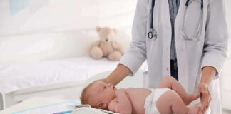 Pediatrician weighing a baby on an infant scale
