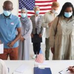 Michigan Muslim Voting Data Reveals Split Protest Voters wearing masks stand in line at a polling station