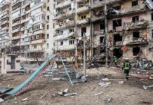 Damaged apartment building behind a playground slide