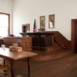 Convicted Rapist Could Seek Parole After Months Interior of a historic courtroom with wooden furniture and an American flag