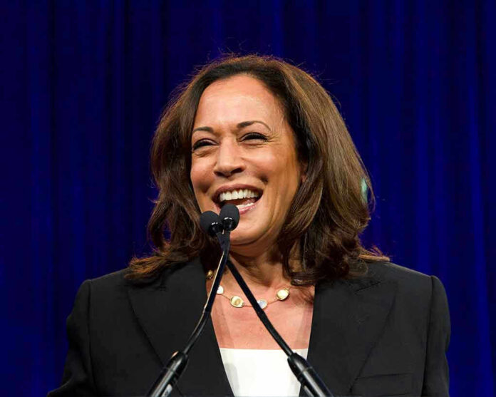 1487795999 Smiling woman speaking at a podium with microphones.