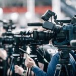 Trump Fights Back After Court Halts Ballroom Broadcast cameras on tripods at a press event