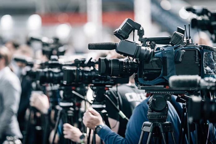 Broadcast cameras on tripods at a press event