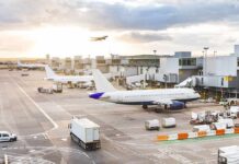 Germany Blames Russia for Airport Drone Plot Airplanes at airport gates during sunset with ground vehicles and jet bridges