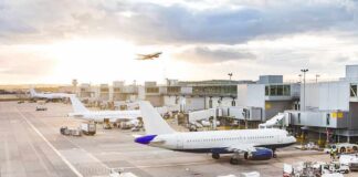 Germany Blames Russia for Airport Drone Plot Airplanes at airport gates during sunset with ground vehicles and jet bridges