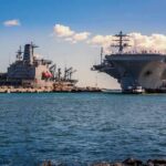 China’s Drone Swarms Challenge America’s Warship Aircraft carrier and support ships docked at a naval harbor
