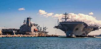 China’s Drone Swarms Challenge America’s Warship Aircraft carrier and support ships docked at a naval harbor