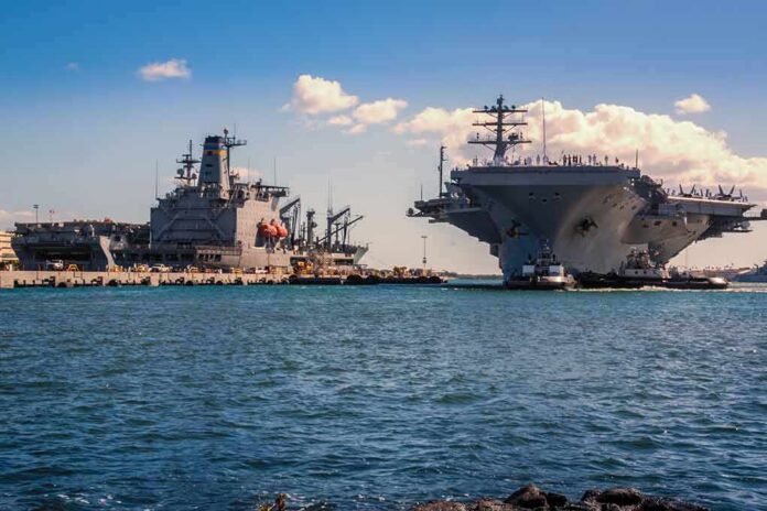 shutterstock_1074924482-1 Aircraft carrier and support ships docked at a naval harbor