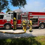Wall-Blowing Electrical Blast Nearly Hits Tacoma Firefighters Fire truck with firefighters operating hoses on a residential street