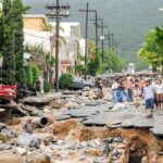 Children Killed: Israeli Strikes Kill 11 in Lebanon, Residents walk along a heavily damaged street after a disaster