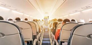 American Airlines Flight Diverted After Passenger Turns Violent airplane cabin with passengers seated in economy class