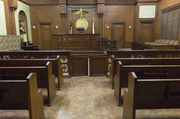 shutterstock_121502665-1 Interior view of an empty courtroom with wooden benches and a judges bench