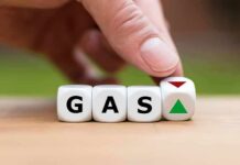 Hand flipping dice showing gas with up and down arrows