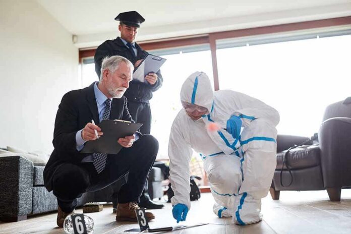 Forensic investigator collects evidence as police and detective observe