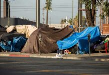 Street tents covered with tarps along a sidewalk