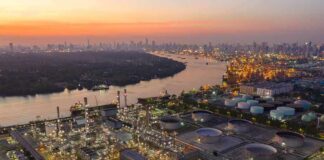 Industrial oil refinery complex beside a river at dusk