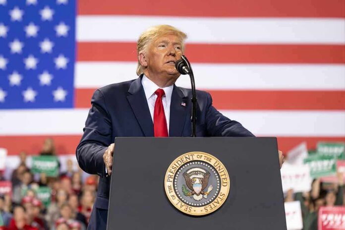 shutterstock_1677446164 Donald Trump speaks at a podium with a U.S. flag backdrop; Teddy Williams and Caraun Reid not visible