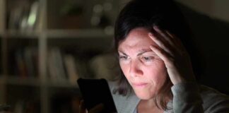 Woman looking at smartphone with worried expression