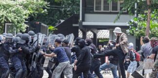 Protesters clash with riot police holding shields