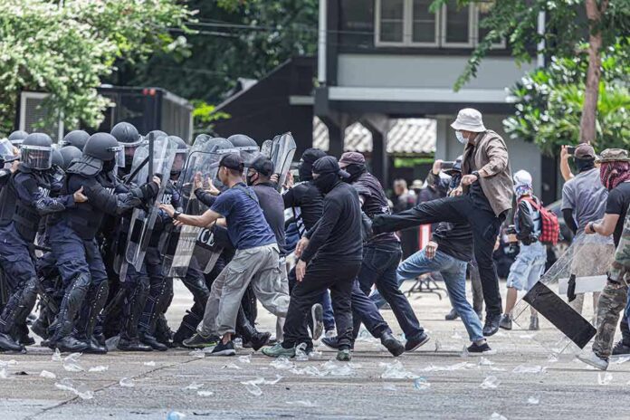 shutterstock_1816967924 Protesters clash with riot police holding shields
