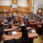 EUROPE RATTLED: Massive Political UPHEAVAL in Romania Legislators raise hands during a vote in a large chamber