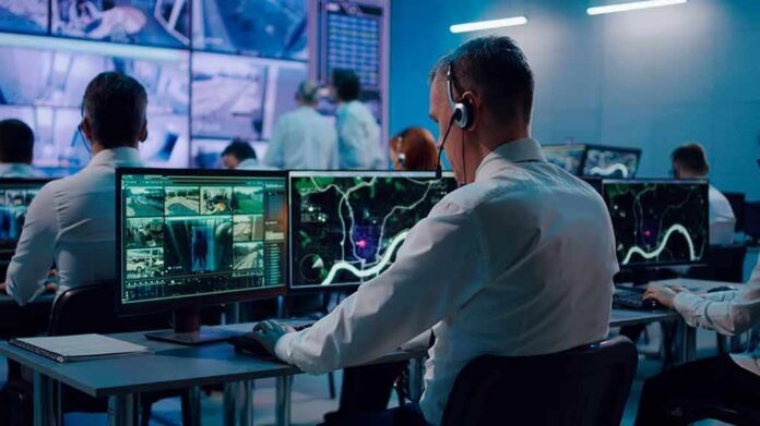 Security analysts monitoring multiple screens in control room