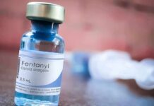 China’s Fentanyl Role Sparks U.S. Debate Fentanyl vial on a table with blurred syringe in background