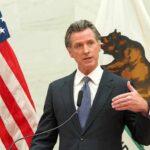 California’s Boldest Tax Gamble Is Now on the Ballot Gavin Newsom speaks at a podium with U.S. and California flags behind him