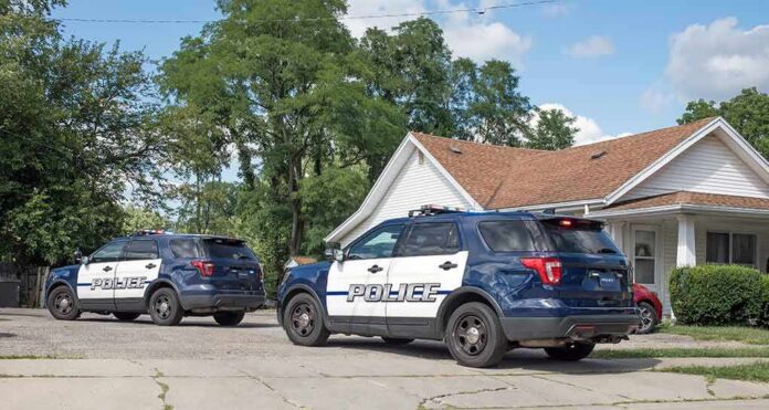 shutterstock_2195086633-2 Two police SUVs parked near a suburban house